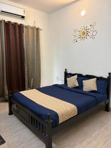 a bedroom with a bed with a blue comforter at Grand home villas in Jāmb +45 photos