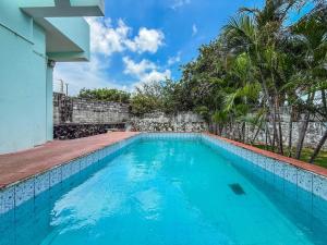 a swimming pool in front of a house with palm trees at Grand home villas in Jāmb