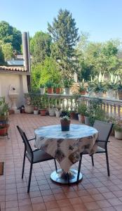 a table and chairs on a patio with potted plants at Millenovecento in Cremona