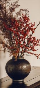a black vase with a plant with red berries at Studio 21 in Hasselroth +35 photos