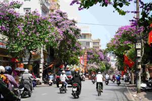 a group of people riding motorcycles down a city street at Phốstay 180 Cầu Đất in Hai Phong