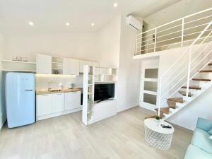 a kitchen with white cabinets and a staircase at Ksenija Deluxe Residence in Tučepi