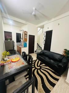a living room with a table and a black leather couch at Grand home villas in Jāmb