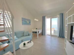 a living room with a blue couch and a table at Ksenija Deluxe Residence in Tučepi
