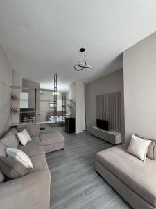 a living room with a couch and a television at Forum View Apartments in Durrës