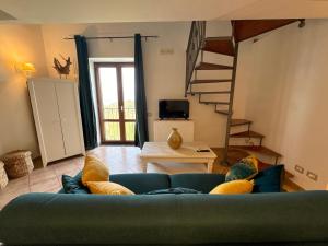a living room with a blue couch and a staircase at Villa Rosmary in Massa Lubrense