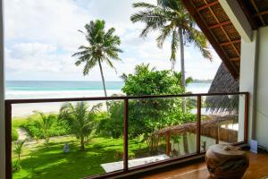 a room with a balcony with a view of the ocean at Villa Ombak in Katiet