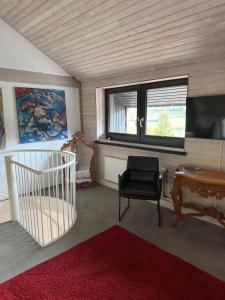ein Zimmer mit einem Stuhl, einem Schreibtisch und einem Fenster in der Unterkunft Lenne Studio in Lennestadt