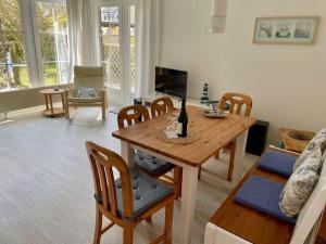 a living room with a wooden table and chairs at FeWo-mit-Terasse-u-Garten-am-Golfplatz in Wulfen auf Fehmarn