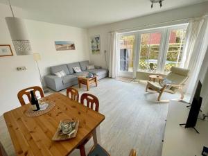 a living room with a table and a couch at FeWo-mit-Terasse-u-Garten-am-Golfplatz in Wulfen auf Fehmarn