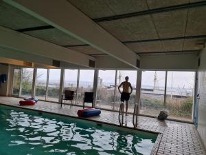a man is standing next to a swimming pool at Panoramaudsigt og swimmingpool midt i Ebeltoft in Ebeltoft +7 photos