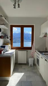 a kitchen with a window and a view of the mountains at Landscapesilvia Acqua in Menaggio