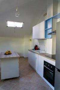 a kitchen with white cabinets and a counter top at Nosside & Saffo Guesthouse in Amantea +19 photos