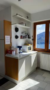 a kitchen with a microwave on a counter with a window at Landscapesilvia Acqua in Menaggio +25 photos