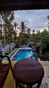 a view of a swimming pool with a table and a chair at Pondok Masa Depan in Sidemen