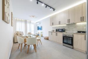 a kitchen and dining room with a table and chairs at Enclave Luxury Apartments in Áyios Kírikos