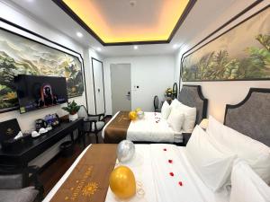 a hotel room with two beds and a desk at Green Luxury Hotel in Hà Ðông