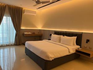 a bedroom with a large bed with white sheets and pillows at Heritage Heaven by Premium Suites in Karachi