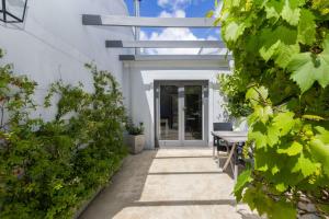 a pathway leading to a white building with a table at Maroon Belles in Cape Town