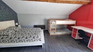 a bedroom with a bed and a desk and a shelf at Gerlande 2 in Bourg-Argental +7 photos