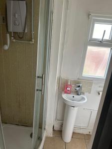 a bathroom with a sink and a window and a shower at Quiet room 5 in Coventry