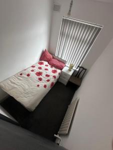 a small bedroom with a bed with red flowers on it at Quiet room 5 in Coventry