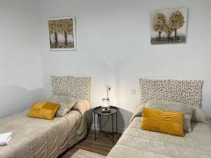 a bedroom with two beds and a table with a lamp at Todimer Costa Peñon in Torrenueva
