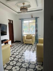 a living room with two chairs and a television at Amour Coco Stay in Chaki Chaki