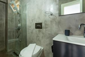 a bathroom with a shower and a toilet and a sink at Westcoast Kalkan Suites 1-bedroom suite located heart of Kalkan Old Town in Kalkan +18 photos