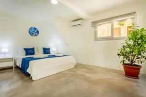 a bedroom with a bed and a potted plant at Westcoast Kalkan Suites 1-bedroom suite located heart of Kalkan Old Town in Kalkan
