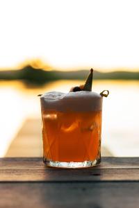 a drink sitting on top of a wooden table at Villa Das Contas Boutique in Itacaré