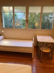 a room with a bed and a table and windows at Chambre indépendante in Saint-Roman