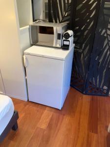 a microwave sitting on top of a refrigerator at Chambre indépendante in Saint-Roman