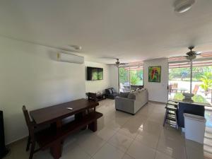 a living room with a couch and a table at Private Pool, Walk to Beach -Los Delfines in Paquera