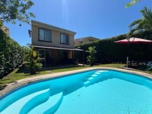 a swimming pool in front of a house at Private Pool, Walk to Beach -Los Delfines in Paquera