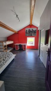 a room with a bed and a red wall at Gerlande 2 in Bourg-Argental