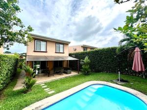 a villa with a swimming pool in front of a house at Private Pool, Walk to Beach -Los Delfines in Paquera