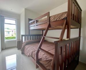 a bedroom with a bunk bed with a ladder at Private Pool, Walk to Beach -Los Delfines in Paquera +19 photos