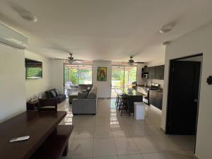 a large living room with a couch and a kitchen at Private Pool, Walk to Beach -Los Delfines in Paquera
