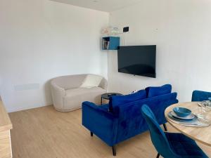 a living room with a blue couch and a table at Duplex d Iroise rénové 2 chambres Centre Gouesnou Parking & Wifi in Gouesnou