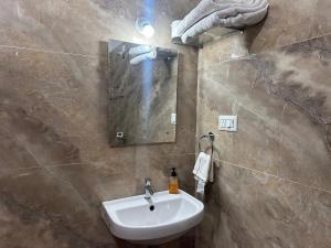 a bathroom with a sink and a mirror at Joy Villa Homestay in Honāvar +22 photos