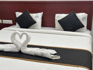 two beds with a swan made out of towels at Joy Villa Homestay in Honāvar