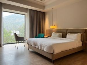 a bedroom with a large bed and a large window at The Supreme Hotel and Banquet in Gaya +62 photos