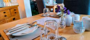 a wooden table with plates and utensils on it at Boherbui B&B in Doolin