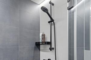 a shower with a black shower head in a bathroom at Relax al Mare with sauna near the sea in Laulasmaa +26 photos