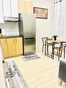 a kitchen with a stainless steel refrigerator and a table at Modern Ground Level 1BR Apartment - Prime Location in North Vancouver