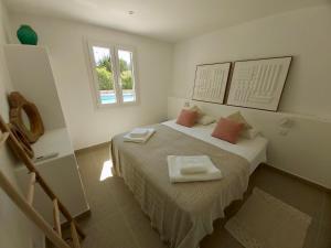 a bedroom with a bed with two towels on it at Los Caballos Villa in Cala Galdana +18 photos