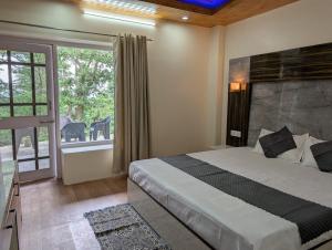 a bedroom with a bed and a large window at Deodar hill top home stay chail in Chail