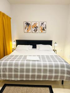 a bedroom with a large bed with a checkered blanket at Modern Ground Level 1BR Apartment - Prime Location in North Vancouver