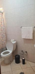 a bathroom with a toilet and a shower curtain at Apart savane in São Filipe +19 photos
